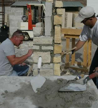 Two bricklaying apprenticeship students working on a project.