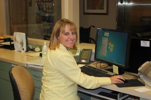 Keezia Wadsworth sits at a desk with a computer.