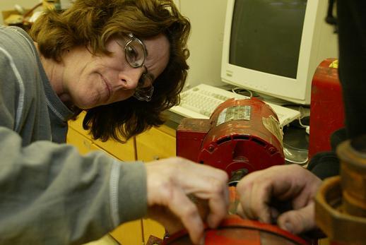 Female student in glasses working on a steamfitters machine