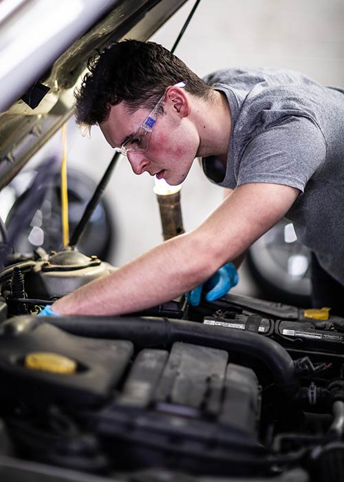 auto mechanic student working on a car engine